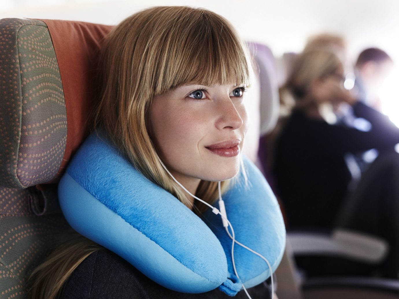 Girl wearing a neck pillow on a plane